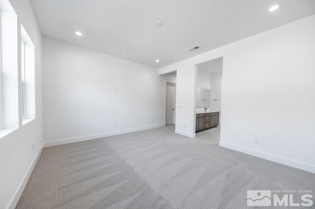 spare room featuring light colored carpet