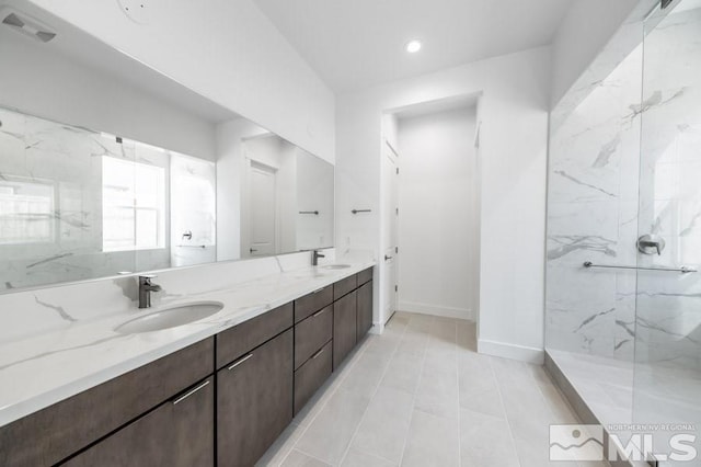 bathroom featuring a tile shower, vanity, and tile patterned floors