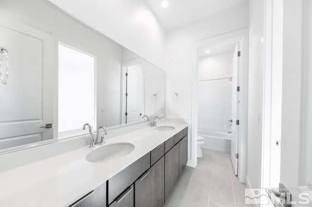 full bathroom with tile patterned flooring, vanity,  shower combination, and toilet