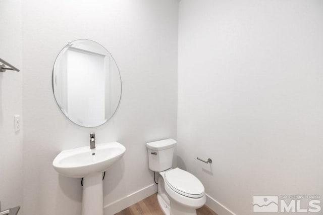 bathroom with toilet and wood-type flooring