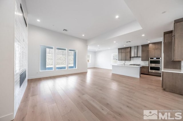 unfurnished living room with sink and light wood-type flooring