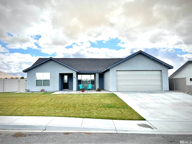 view of front of home featuring a front lawn, a garage, and a mountain view