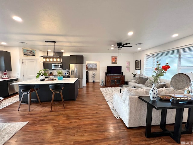 living room featuring ceiling fan and dark hardwood / wood-style flooring