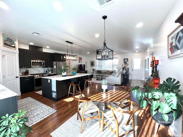 dining space featuring dark wood-type flooring and a textured ceiling