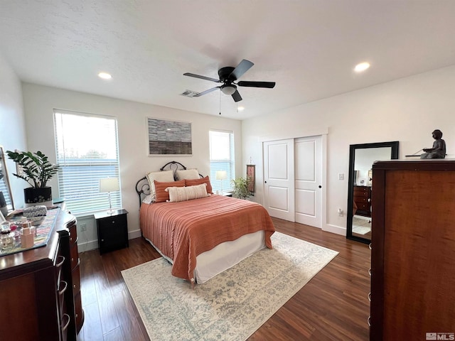 bedroom featuring ceiling fan, dark wood-type flooring, and a closet