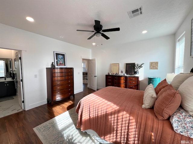 bedroom with ceiling fan, a textured ceiling, dark hardwood / wood-style floors, and ensuite bathroom