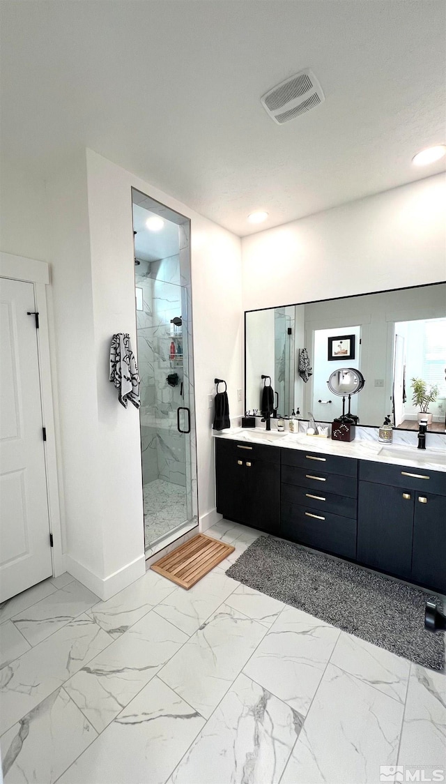 bathroom with vanity and a shower with door