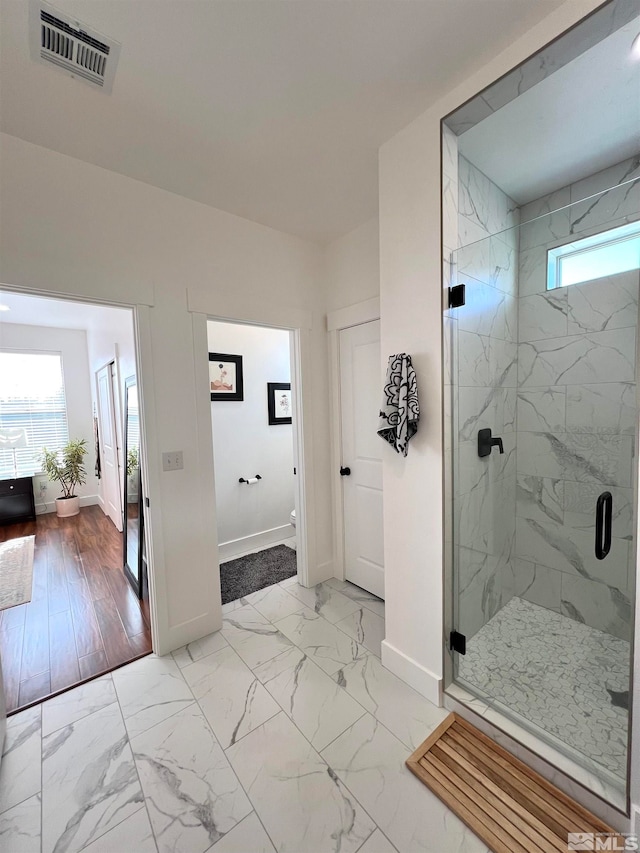 bathroom featuring plenty of natural light and a shower with door