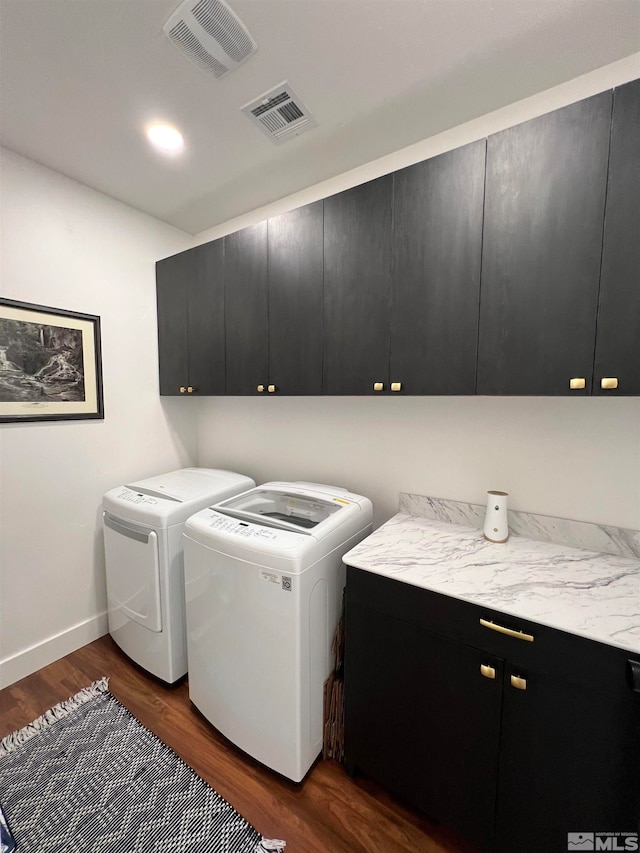 laundry area featuring dark wood-type flooring, cabinets, and washer and dryer