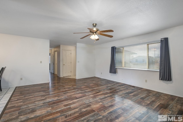 unfurnished living room with dark hardwood / wood-style floors and ceiling fan