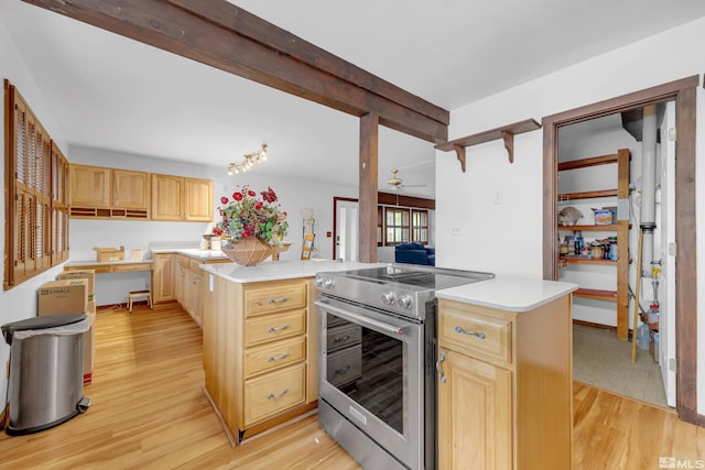 kitchen with a center island, electric range, light wood-type flooring, and light brown cabinets