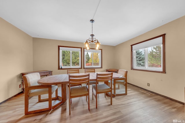 dining area featuring light hardwood / wood-style floors, a notable chandelier, and plenty of natural light