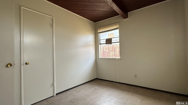 spare room with baseboards, beamed ceiling, and wood ceiling