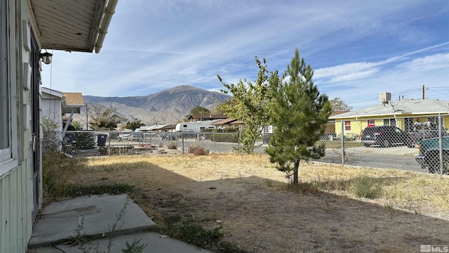 view of yard featuring fence and a mountain view