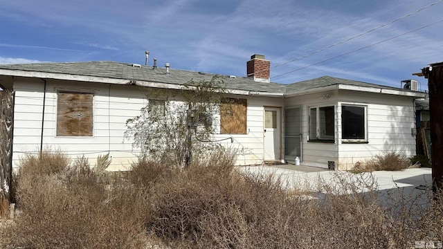rear view of property featuring a chimney