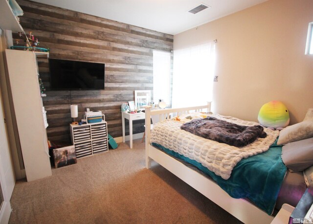 bedroom with wood walls and carpet flooring