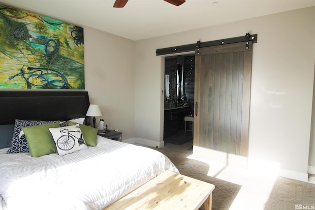 carpeted bedroom with a barn door and ceiling fan