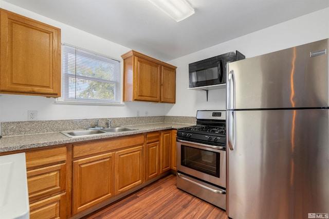 kitchen featuring hardwood / wood-style floors, stainless steel appliances, and sink