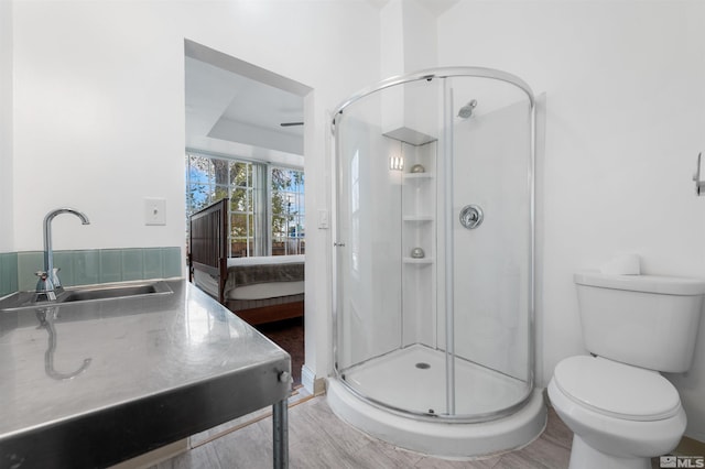 bathroom with toilet, an enclosed shower, hardwood / wood-style flooring, and sink