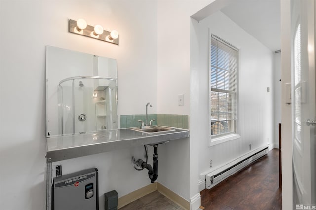 bathroom featuring a shower with shower door, wood-type flooring, sink, and baseboard heating