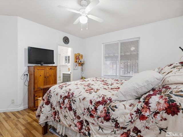 bedroom with connected bathroom, light hardwood / wood-style flooring, and ceiling fan