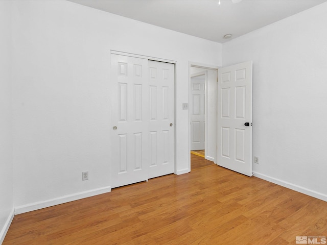 unfurnished bedroom with a closet and light wood-type flooring