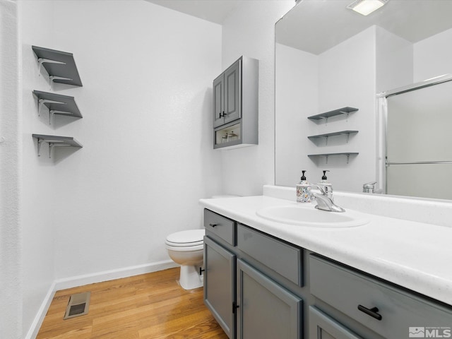 bathroom with vanity, toilet, wood-type flooring, and walk in shower