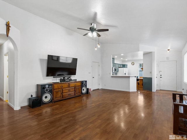 living room featuring lofted ceiling, dark wood-type flooring, and ceiling fan