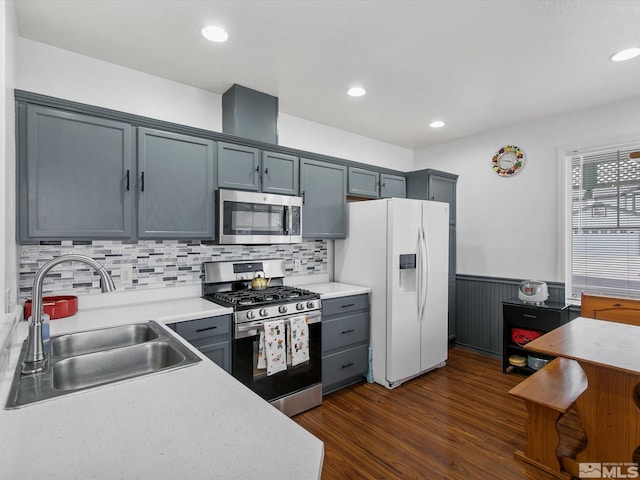 kitchen with gray cabinetry, sink, backsplash, stainless steel appliances, and dark hardwood / wood-style floors