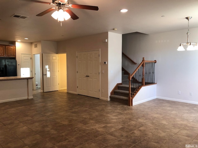 unfurnished living room with ceiling fan with notable chandelier