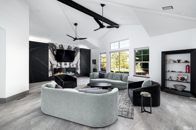 living room with a fireplace, ceiling fan, tile walls, beam ceiling, and high vaulted ceiling