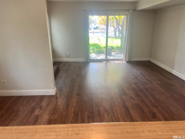 spare room with dark wood-type flooring