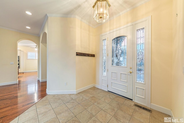 foyer entrance featuring crown molding, a notable chandelier, and light hardwood / wood-style floors