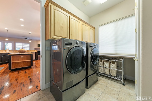 laundry area featuring cabinets, separate washer and dryer, and light tile patterned floors