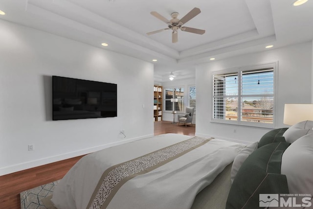 bedroom featuring a raised ceiling, ceiling fan, and dark hardwood / wood-style flooring