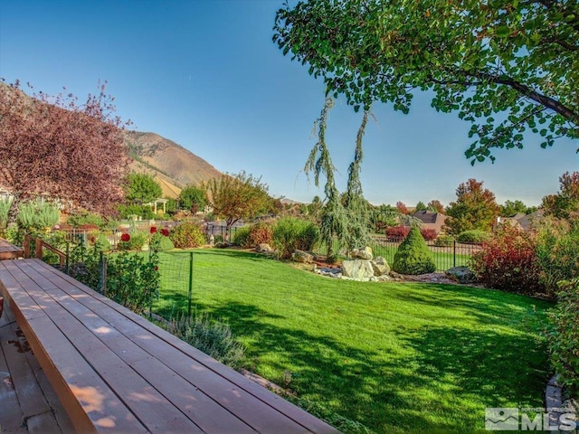 view of yard with a deck with mountain view