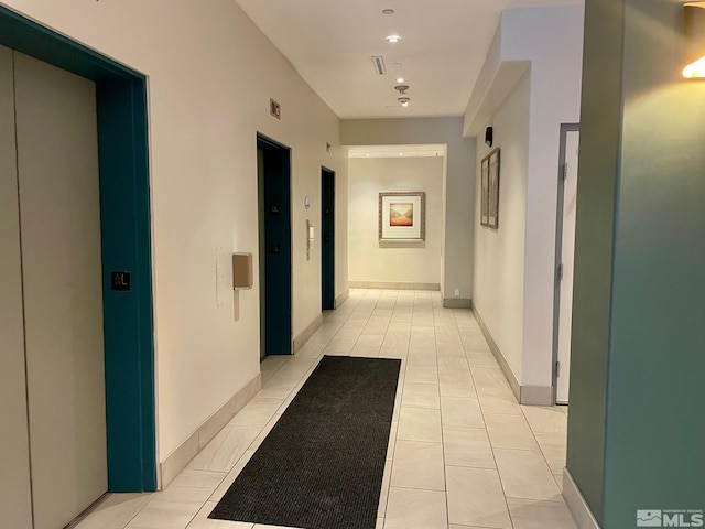 hallway with light tile patterned floors and elevator