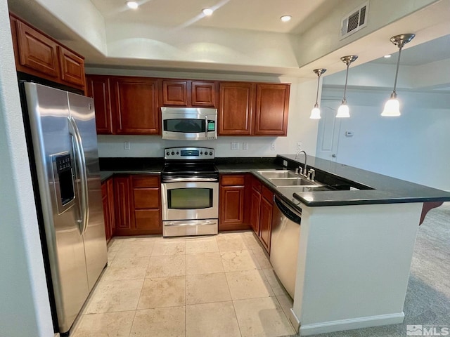 kitchen featuring kitchen peninsula, pendant lighting, sink, and stainless steel appliances