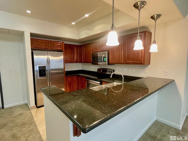 kitchen featuring dark stone countertops, kitchen peninsula, stainless steel appliances, and hanging light fixtures