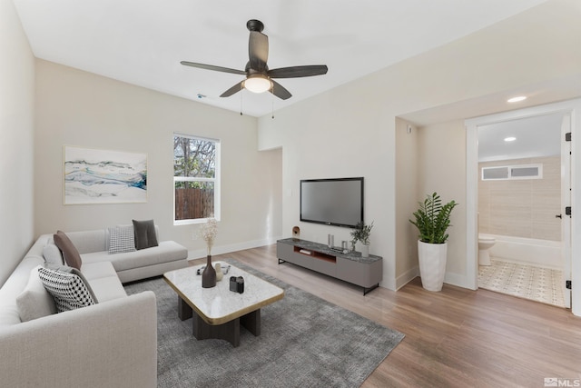 living room featuring ceiling fan and hardwood / wood-style flooring