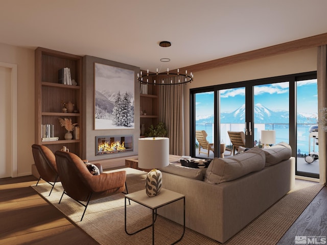 living room featuring light hardwood / wood-style floors, an inviting chandelier, and a water view