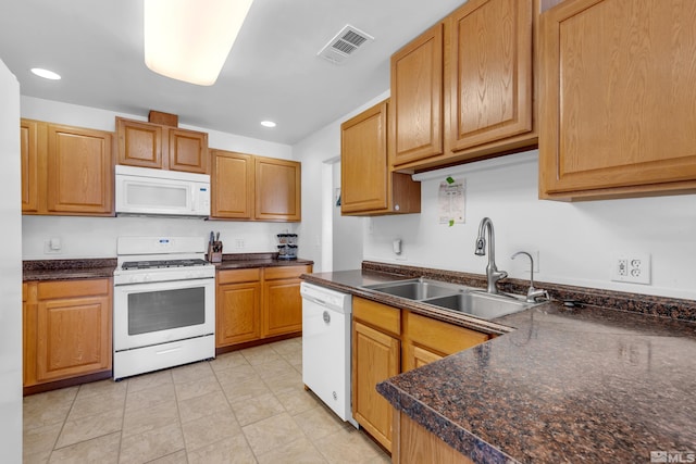 kitchen featuring white appliances, light tile patterned floors, and sink