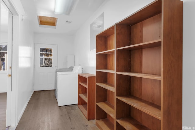 washroom with light hardwood / wood-style flooring and washer and clothes dryer