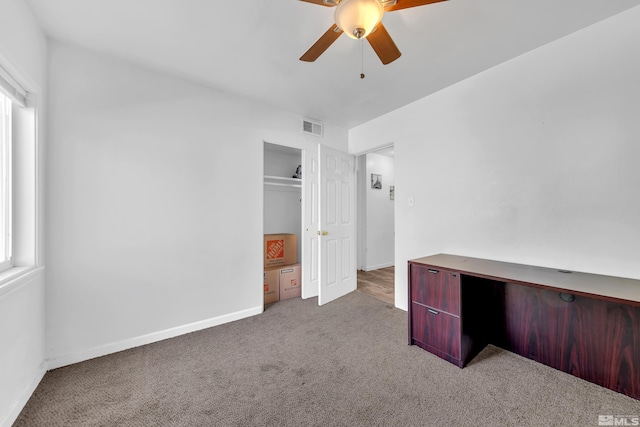 unfurnished office featuring carpet and ceiling fan