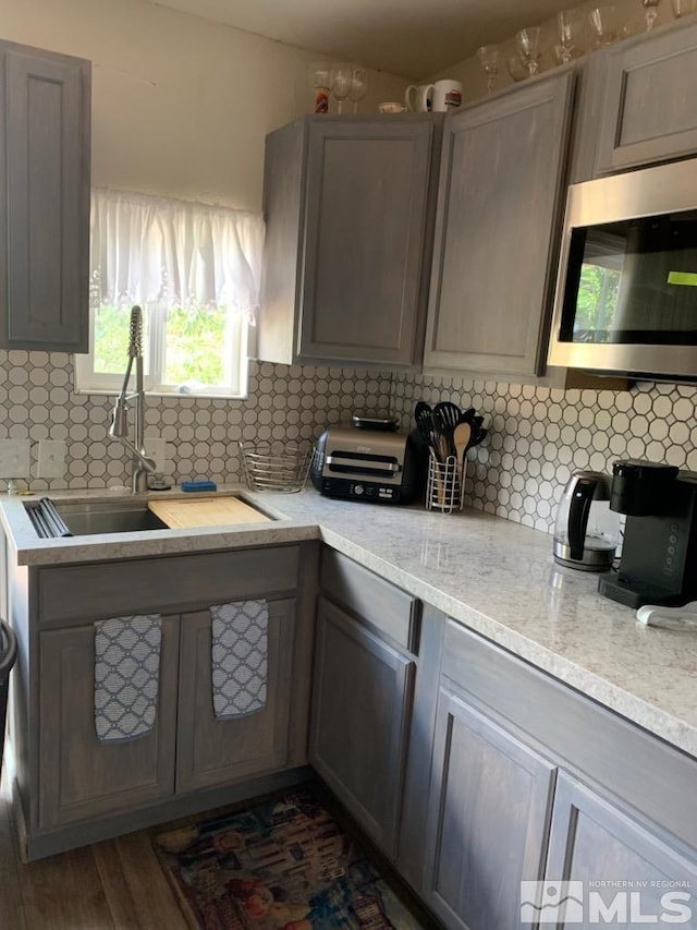 kitchen featuring gray cabinets, decorative backsplash, sink, and dark hardwood / wood-style flooring