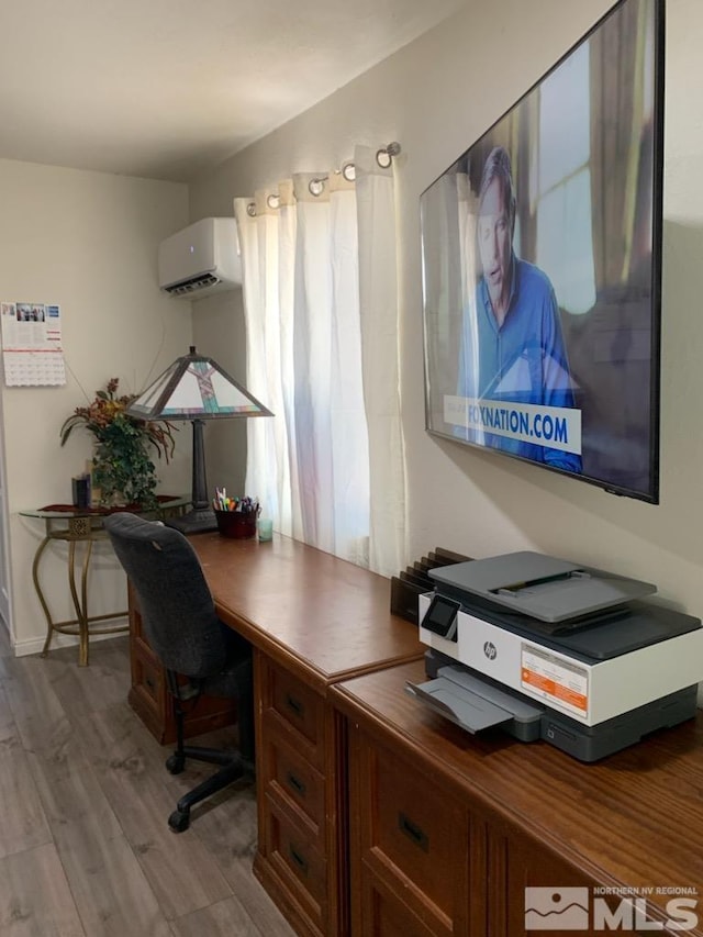 office with light hardwood / wood-style flooring and an AC wall unit