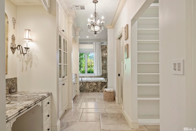 interior space with built in features, ornamental molding, and a chandelier