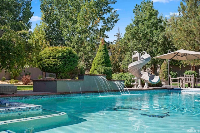 view of pool with a water slide and pool water feature