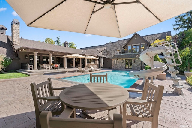 view of pool featuring a patio area and a water slide