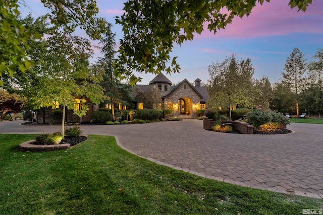 french country home featuring a yard